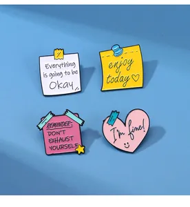 Détail d'un lot de quatre épingles en émail colorées avec des phrases inspirantes
