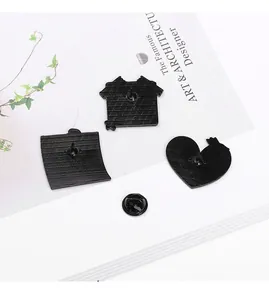 Détail des épingles en émail noir avec dos métallique texturé et fermoirs papillon