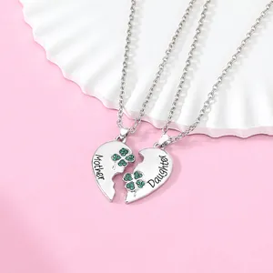 Detail of mother and daughter split heart necklaces with engraved text and clover charm