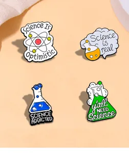Macro detail of science enamel pins featuring Erlenmeyer flasks and atomic models