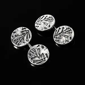Detailaufnahme von Vintage Silber-Manschettenknöpfen mit geprägtem Blattmuster