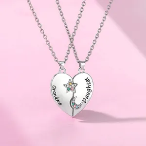 Macro shot of silver heart puzzle necklaces engraved with Grandma and Daughter text