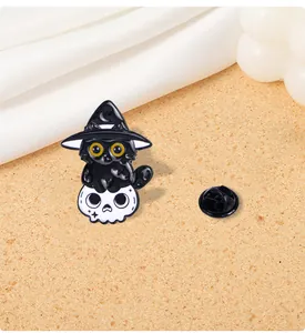 Close-up of Halloween enamel pin with black cat on skull next to a rubber back clasp