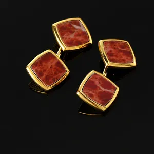Nahaufnahme vintage goldene Manschettenknöpfe mit rotbraunem Marmor auf schwarzer Oberfläche