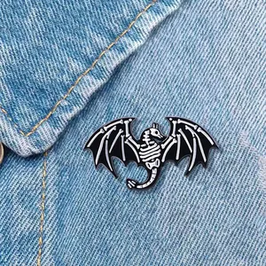 Broche en émail squelette de dinosaure noir et blanc sur tissu en denim bleu