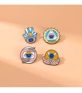 Detail view of four mystical blue eye enamel pins on a warm orange background