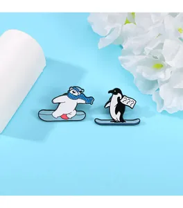 Dettaglio di simpatiche spille in smalto con orso polare e pinguino su skateboard