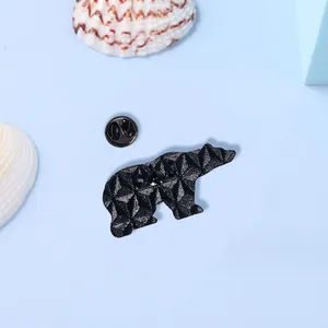 Vue détaillée du dos d'un pin's en émail en forme d'ours avec fermoir papillon noir