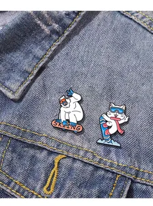 Dettaglio delle spille da sci a fumetti con pupazzo di neve e gatto su giacca di jeans