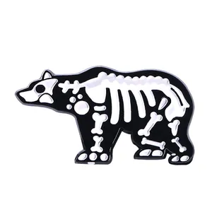 Détail du pin's en émail silhouette d'ours avec motif de squelette noir et blanc