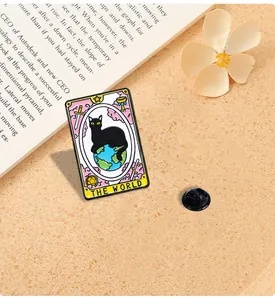 Detail of tarot card 'The World' enamel pin with black cat and globe on book background