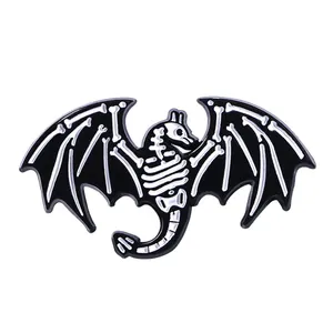 Détail de la broche créative en émail noir représentant un squelette de dinosaure chauve-souris