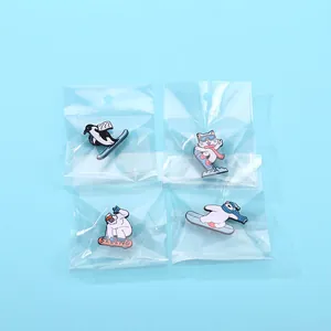 Primo piano di quattro simpatici pin in smalto di animali che sciano in pacchetto retail