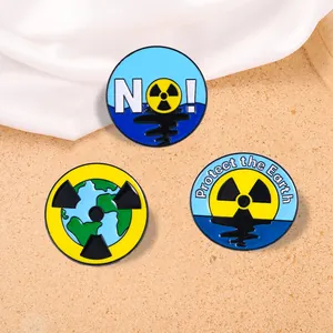 Trois broches en émail écolo avec signes de radiation et slogan Protect the Earth sur tissu