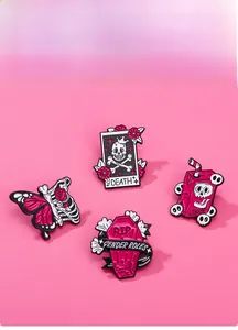 Close-up of pink punk skeleton enamel pins including coffin and death card designs
