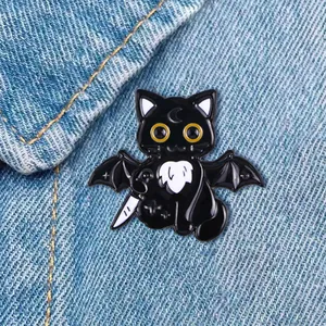 Cartoon black cat enamel pin with bat wings and dagger on blue denim fabric background