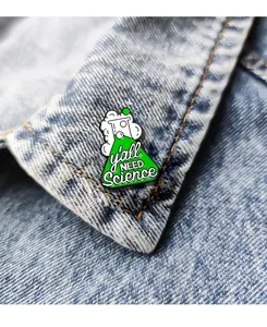 Detail of creative 'y'all NEED Science' enamel flask pin pinned on blue denim jacket