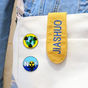 Gros plan de pin's en émail écologiques avec signes de radiation sur un sac en toile