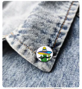 Dettaglio di una spilla smaltata a cactus con sombrero su giacca di jeans blu