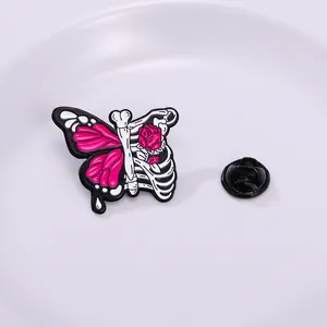 Detailed close-up of punk pink rose butterfly ribcage enamel pin with a metal butterfly clutch