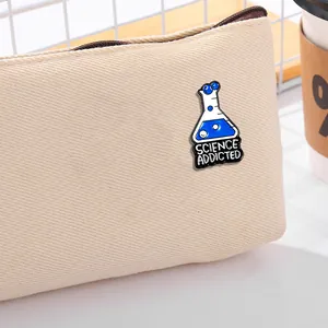 Science Addicted enamel pin with blue conical flask design on canvas bag background