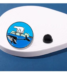 Détail du pin's émaillé rond montrant un ours polaire et un squelette de baleine