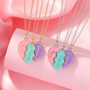 Detalle de los collares Best Friends Forever en forma de corazón sobre satén rosa