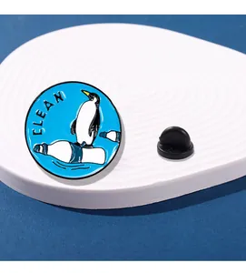 Détail du pin's émaillé de protection des océans avec un pingouin sur une bouteille