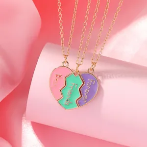 Detalle de tres colgantes de corazón tipo puzzle con texto Best Friends Forever y cadenas