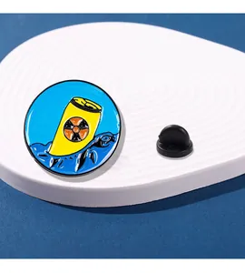 Gros plan détaillé du badge émaillé bleu avec baril jaune et tortue marine