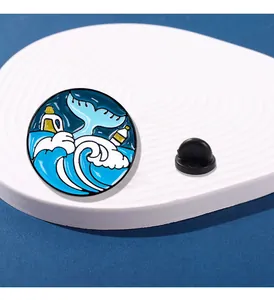 Détail d'une broche en émail queue de baleine et vagues sur plateau de présentation