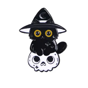 Enamel pin featuring a cute black cat wearing a wizard hat sitting on a white skull