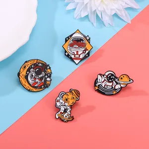 Detailed set of four enamel astronaut pins with celestial motifs on a colorful background