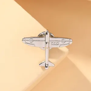 Macro view showing vintage silver airplane brooch with polished metal details and texture