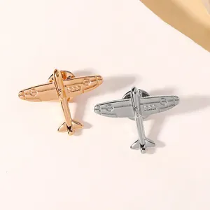 Detailed macro view of gold and silver vintage airplane lapel pins with polished finish