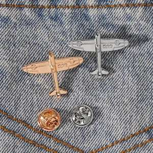 Creative minimalist metal airplane brooch set in silver and rose gold on denim