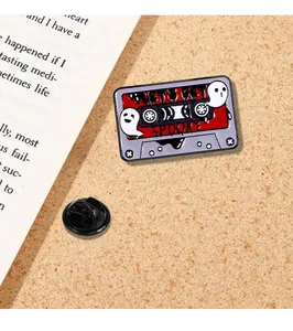 Macro view of retro cassette enamel pin with Let's Get Spooky text and ghost design