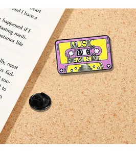 Macro view of vintage music cassette enamel pin with Music Heals Me text and back clasp