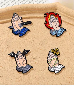 Detailed set of four enamel pins with praying hands, dagger, and gothic wing symbols