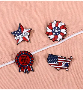 Detail of four enamel USA flag pins on pink fabric, featuring patriotic July 4th designs