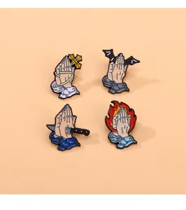 Set of four cartoon enamel pins featuring praying hands with crosses and daggers