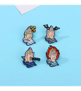 Set of four cartoon enamel pins featuring praying hands with gothic elements on blue background