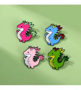 Close-up of four colorful enamel dragon brooches with pitaya fruit inspired patterns