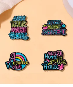 Set of 4 colorful enamel pins with motivational quotes like Less Talk More Work