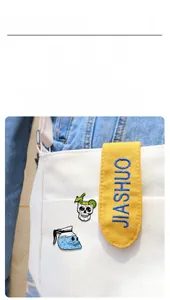 Detail of skull cocktail and coffee pot enamel pins pinned on a white canvas bag