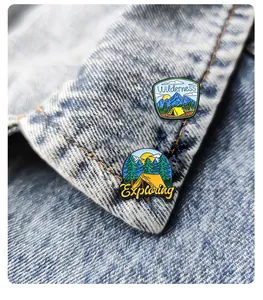 Detail of outdoor camping enamel pins with mountain designs on denim jacket collar