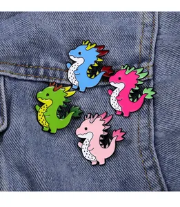 Set of four colorful dragon enamel pins on blue denim, featuring cute fruit-inspired designs
