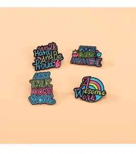 Set of four colorful enamel pins with motivational quotes and sleek black metal edges