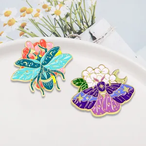 Incantevoli spille smaltate con scarabeo blu e falena viola con motivi celesti di luna e stelle
