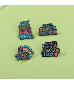 Detail view of four colorful enamel pins with motivational quotes on a green background